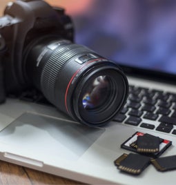 Digital camera sits on top of a laptop