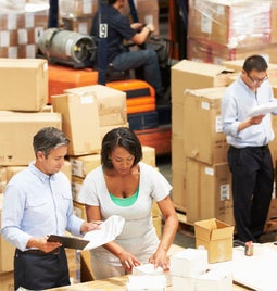 Team of people work together in an ecommerce warehouse to fulfill customer orders