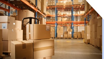 Boxes on a trolley in a warehouse fulfillment center with shelves in the background