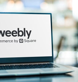 Laptop sits on table showing the Weebly logo