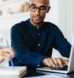 Two people working over a laptop